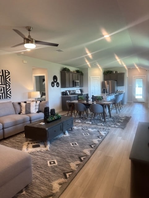 Living area featuring vaulted ceiling, a ceiling f