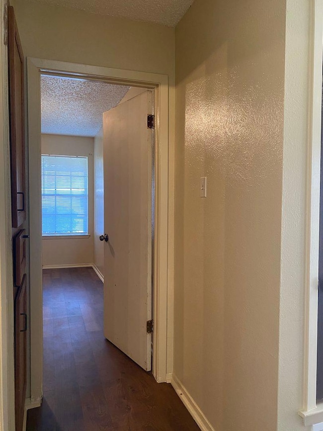Hall featuring dark wood-type flooring, a texture
