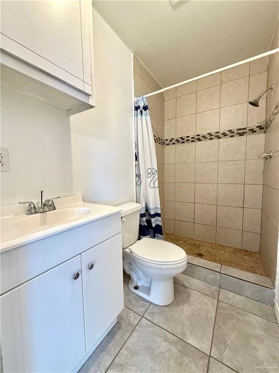 Bathroom with a shower stall, vanity, and tile patterned flooring