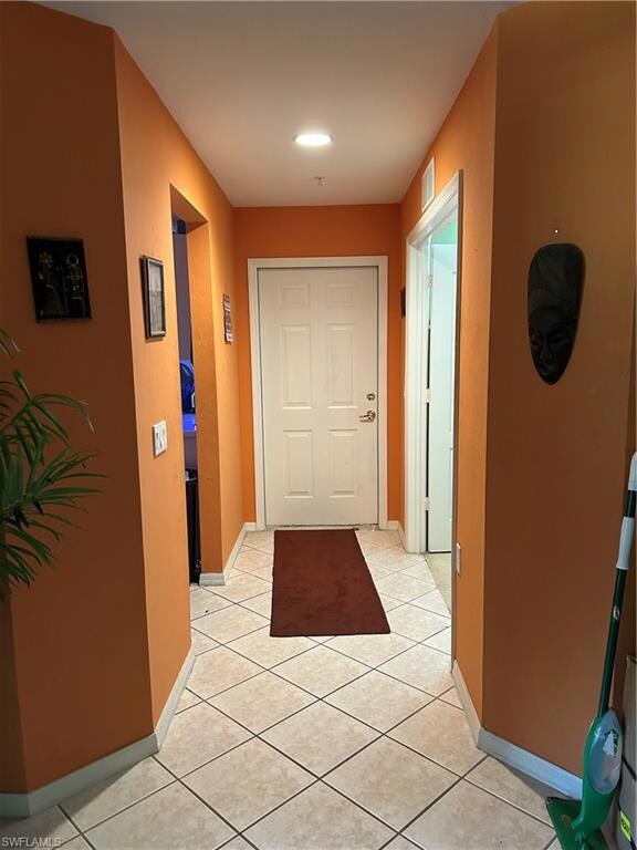 Corridor with visible vents, baseboards, and light