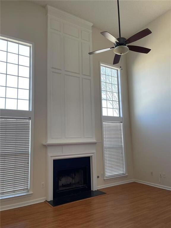Unfurnished living room with ceiling fan, hardwood