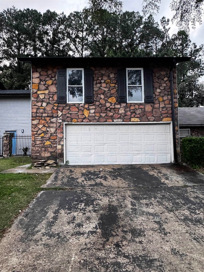 Garage with concrete driveway and fence