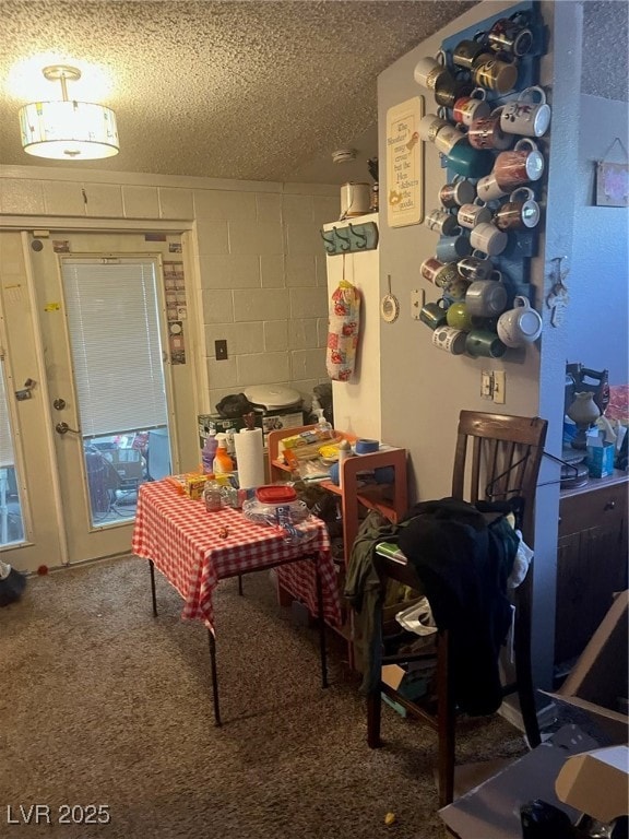 Dining area with carpet, concrete block wall, and