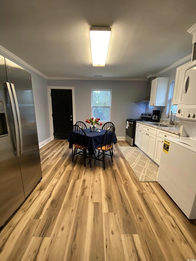 Kitchen with white cabinetry, sink, crown molding,