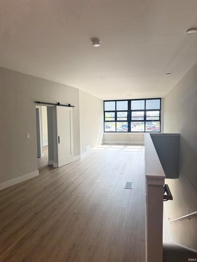 Looking into your living area in your 2nd level apartment with a ton of natural light and a stairway that goes right down to your work space!