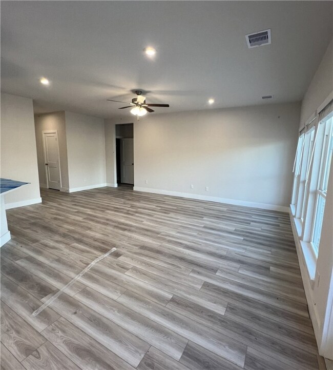 Unfurnished room featuring a ceiling fan, wood fin
