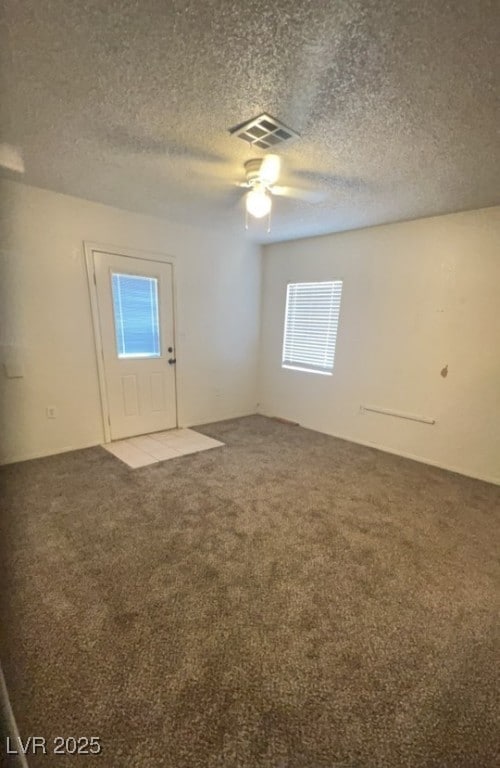 Spare room featuring carpet floors, a ceiling fan,