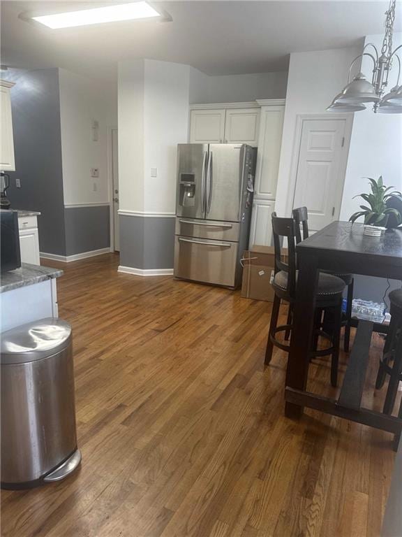 Kitchen featuring white cabinets, dark stone count