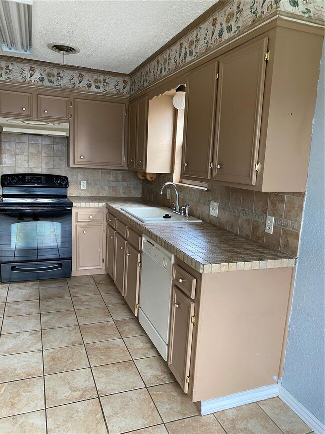 Kitchen featuring stove, dishwashing machine, ligh