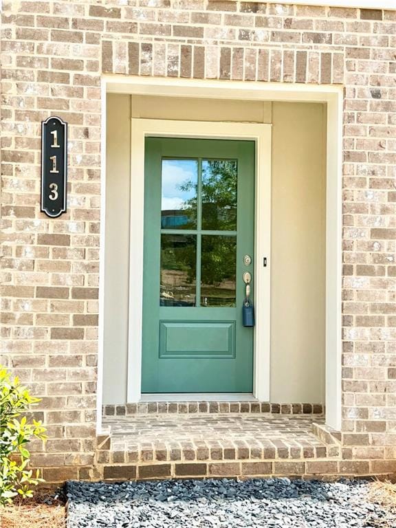 Property entrance featuring brick siding