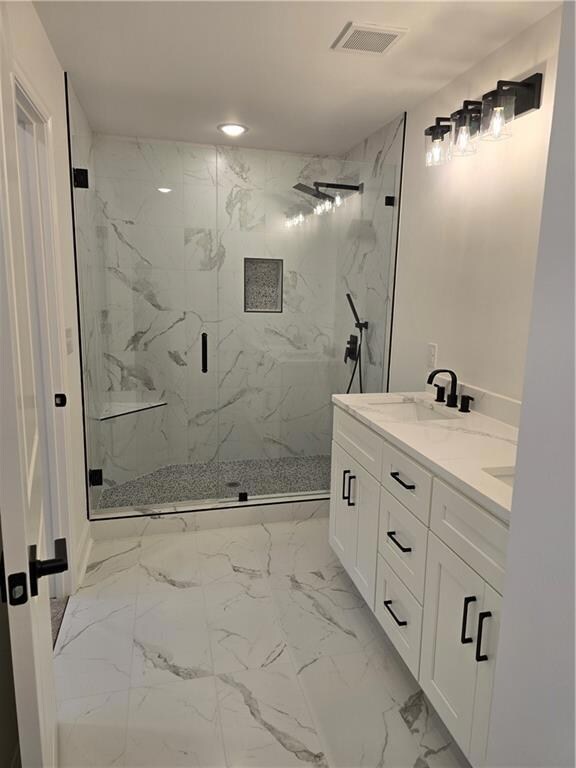 Full bathroom with light marble finish floors and a marble finish shower
