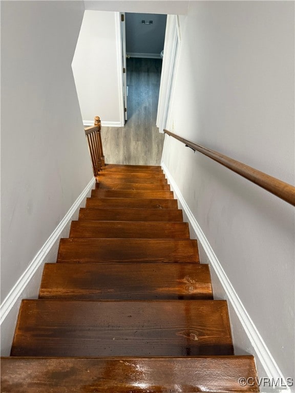 Staircase featuring wood finished floors and baseb