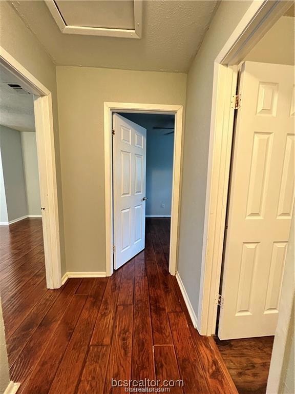 Corridor with dark hardwood / wood-style flooring