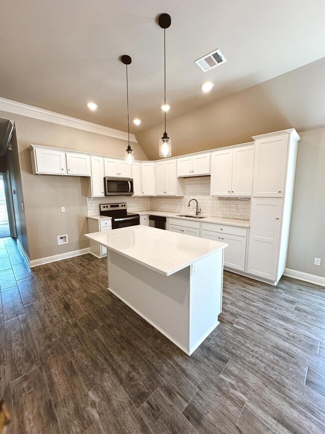 Kitchen featuring a kitchen island, appliances wit