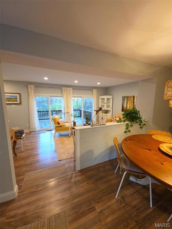 Dining space with dark wood-style floors and recessed lighting