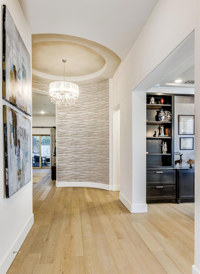 The anchor of the home is this charming rotunda. Curved walls are accented artistically with glamorous wallpaper and accent paint