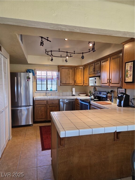 Kitchen with light tile patterned floors, tile cou