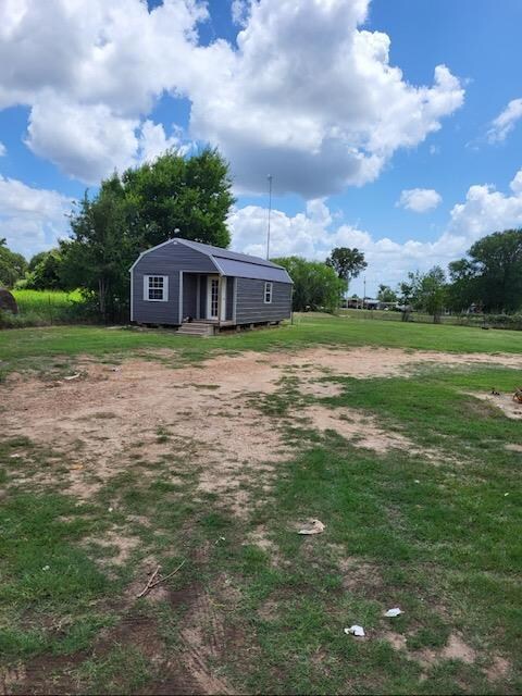 View of green lawn with an outbuilding