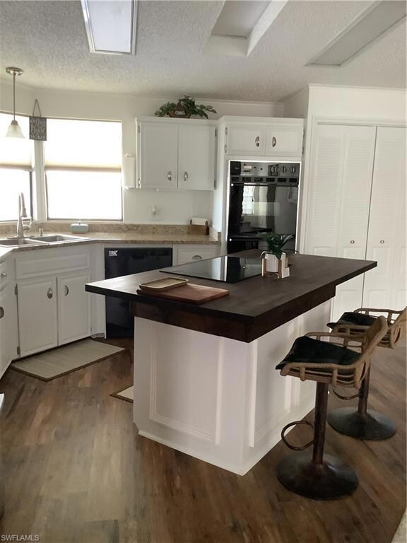 Kitchen featuring oven, white cabinetry, a texture