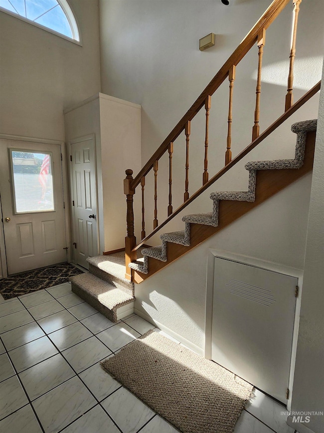 Foyer entrance featuring a towering ceiling and stairway