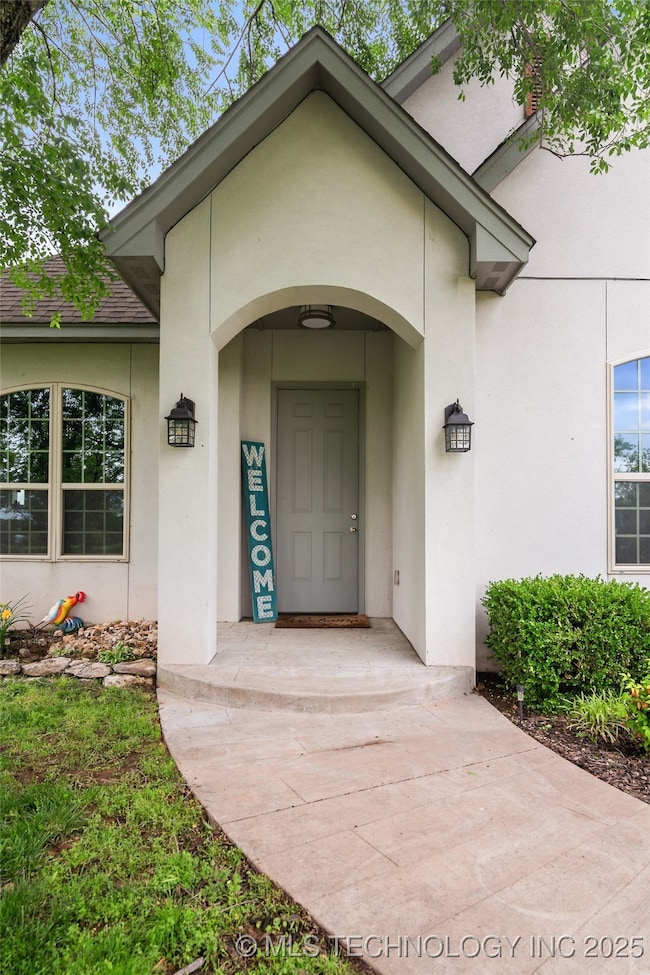 View of exterior entry with stucco siding