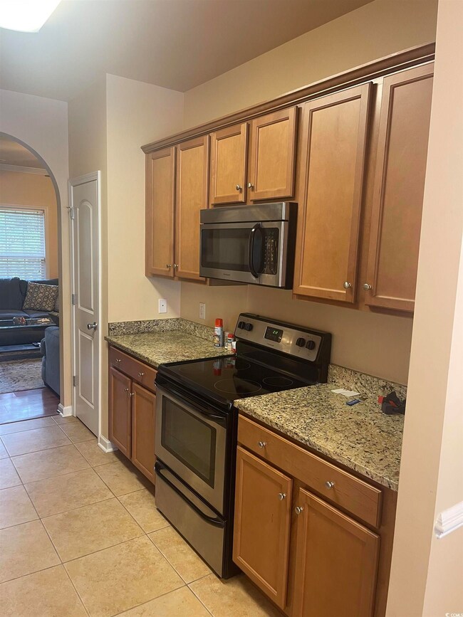Kitchen featuring light tile patterned floors, sta