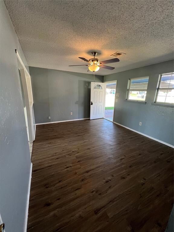 Unfurnished room featuring dark hardwood / wood-style floors, a textured ceiling, and ceiling fan