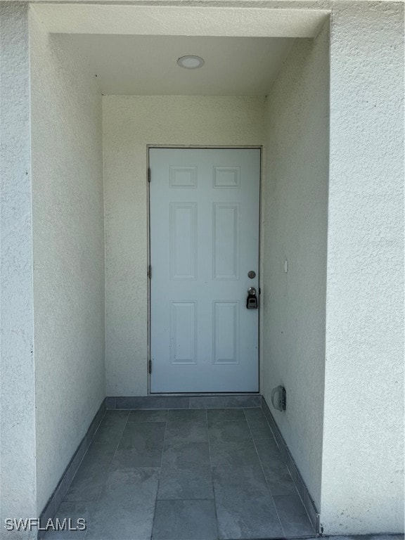 View of exterior entry featuring stucco siding