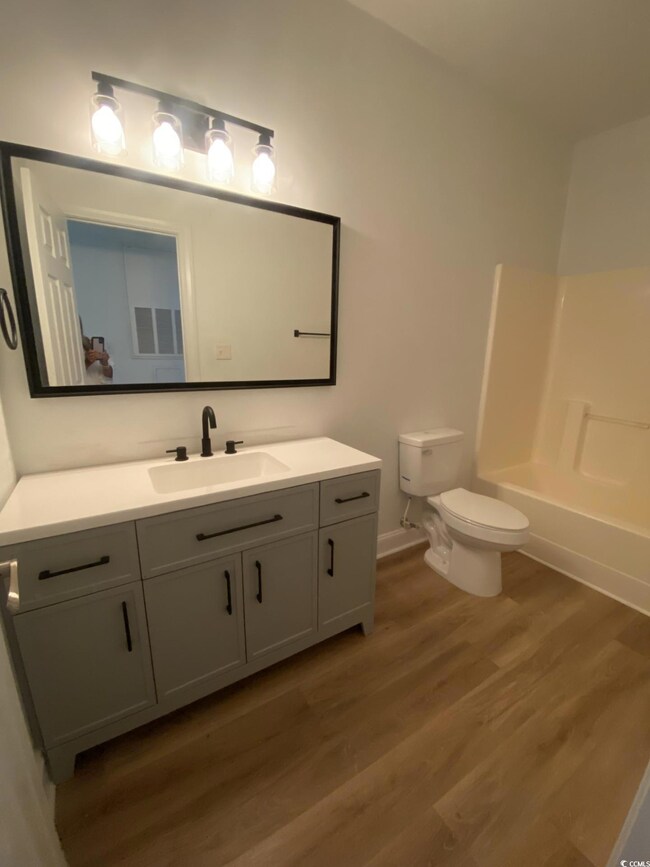 Full bathroom with vanity, wood finished floors, and shower / bath combination