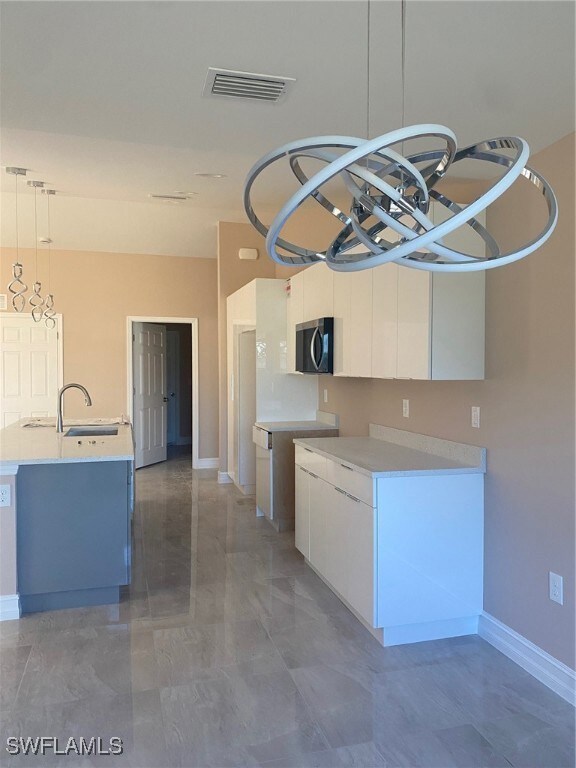 Kitchen with baseboards, a sink, modern cabinets,