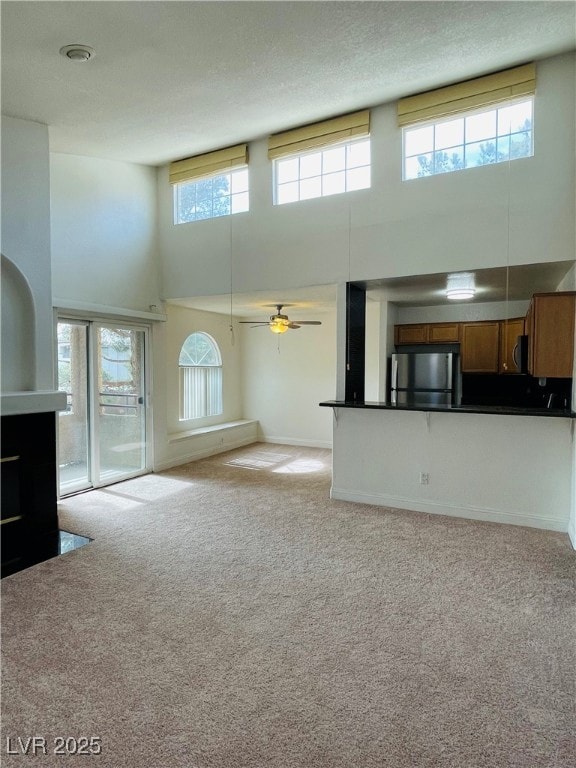 Unfurnished living room featuring a high ceiling,