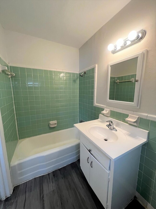 Bathroom with vanity, wood finished floors, batht