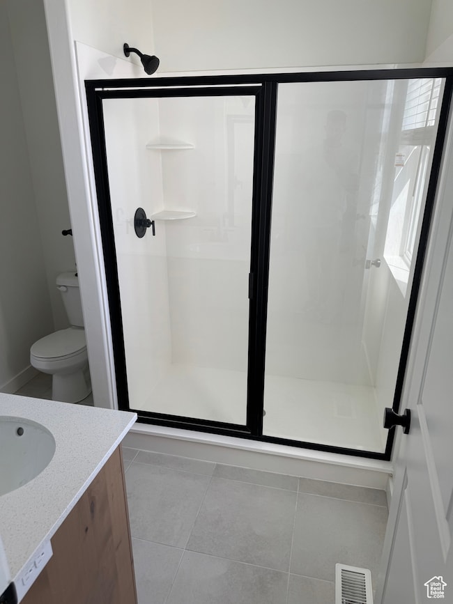 Full bath featuring light tile patterned floors, vanity, and a stall shower