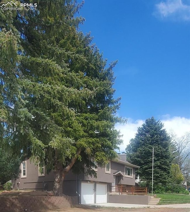 Front view of property with stucco siding and a ga