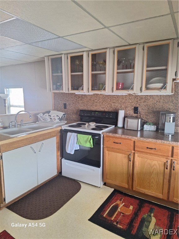 Kitchen with glass insert cabinets, a paneled ceil