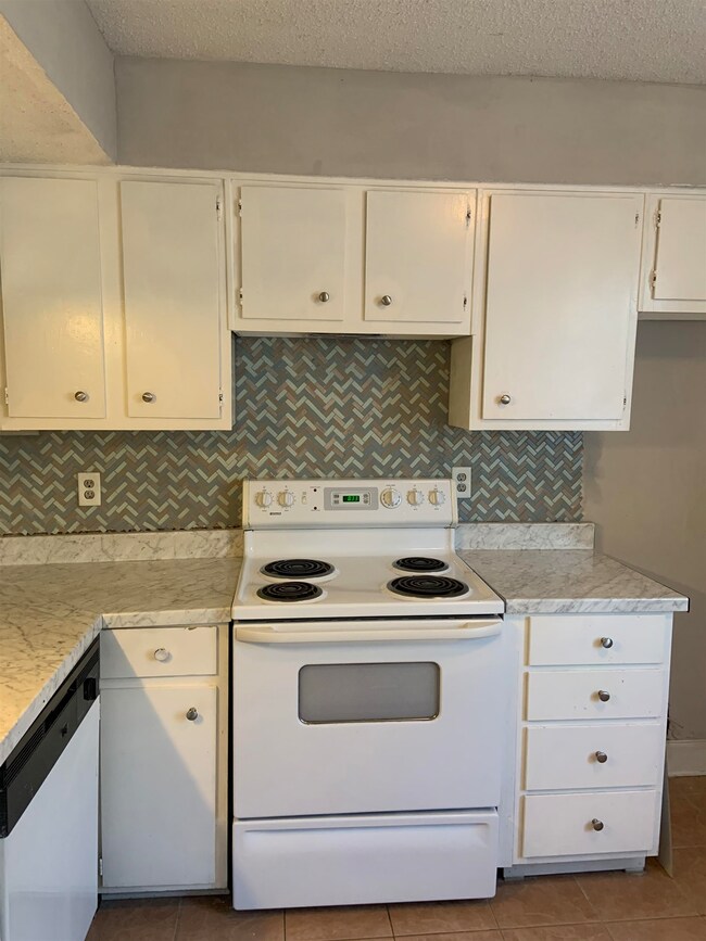 Kitchen with white cabinets, white appliances, lig