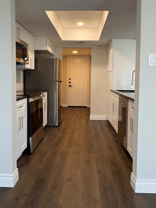 Kitchen with stainless steel appliances, dark cou