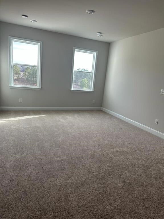 Carpeted spare room with baseboards