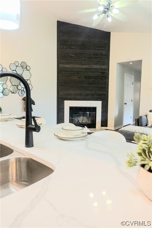 Interior space with a large fireplace, ceiling fan