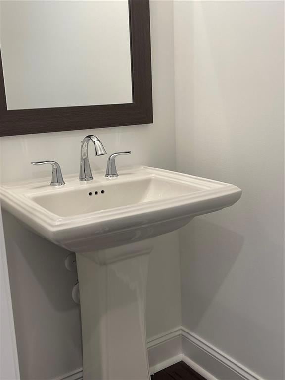 Bathroom featuring baseboards and a sink