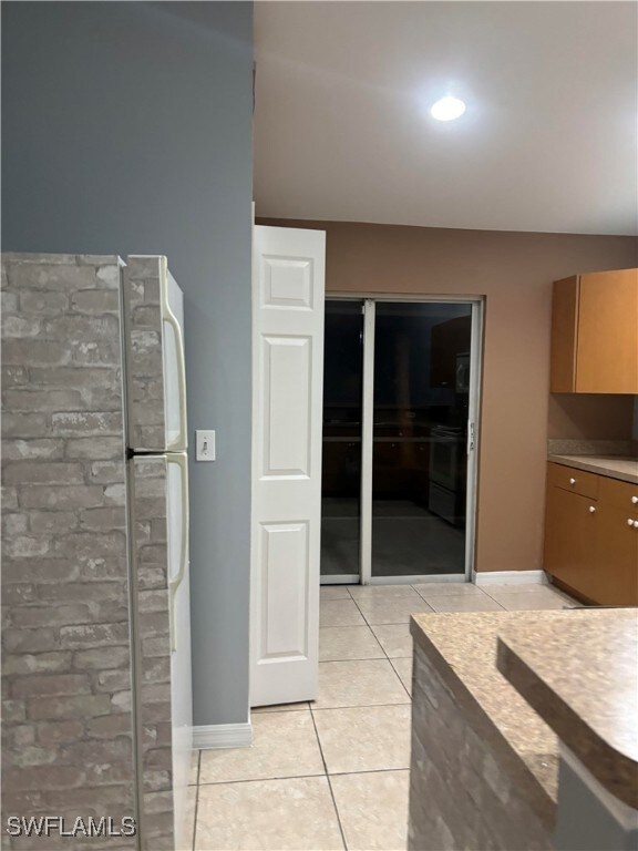 Kitchen featuring light tile patterned floors, bas