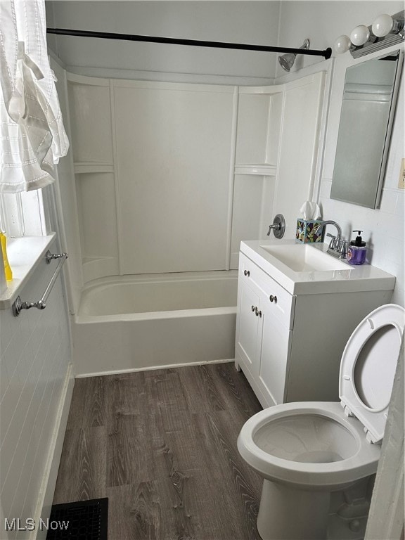 Full bathroom featuring hardwood / wood-style floors,  shower combination, vanity, and toilet