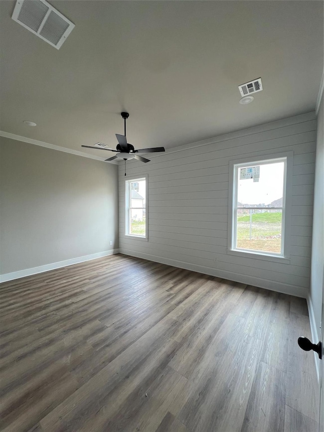 Unfurnished room with visible vents, crown molding
