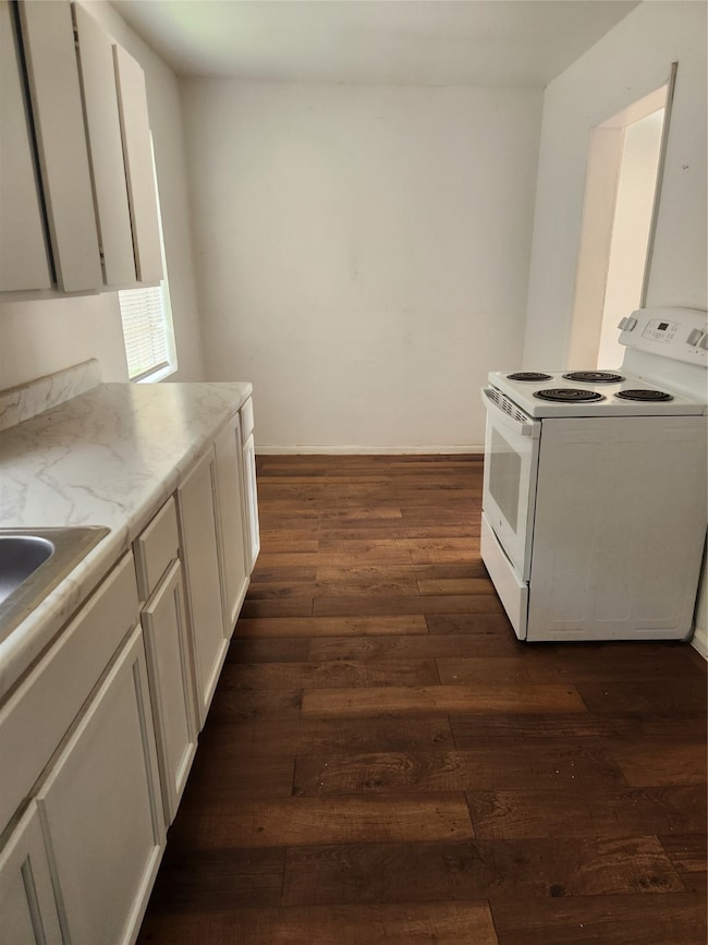 KITCHEN WITH DINING AREA IN THE BACKGROUND.