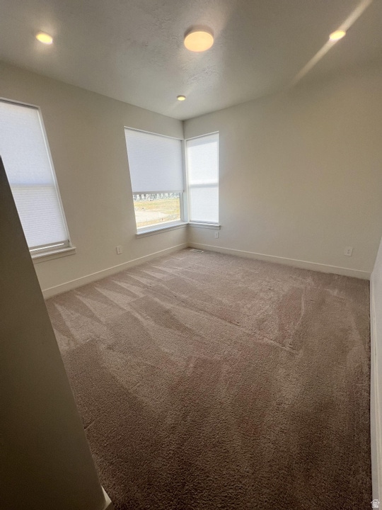Unfurnished room with light carpet and baseboards