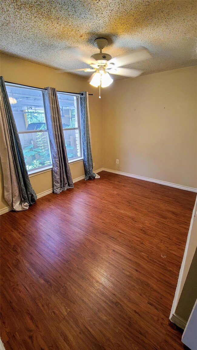 Spare room with a ceiling fan, wood finished floo