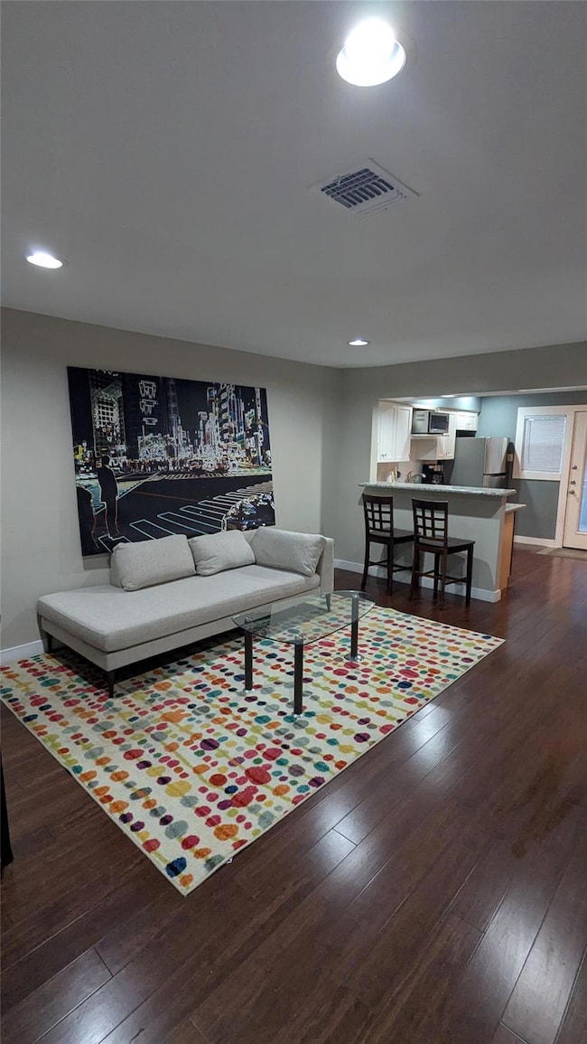 Living room featuring baseboards, dark wood-style