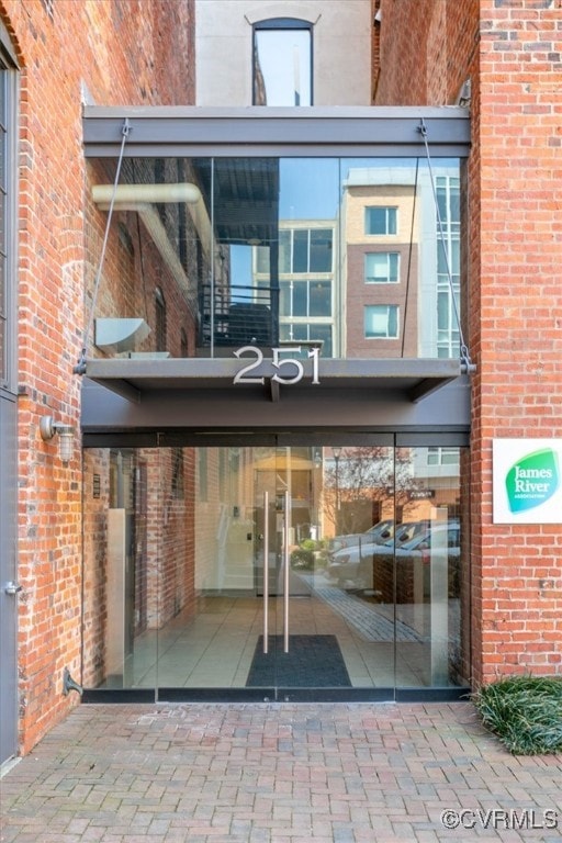 Property entrance with brick siding and a balcony