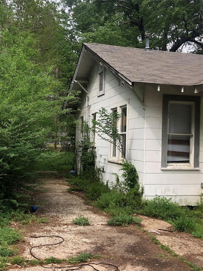 View of side of home with a shingled roof