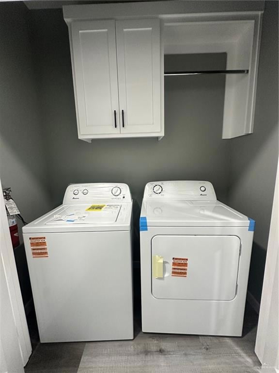 Washroom featuring cabinet space and independent washer and dryer